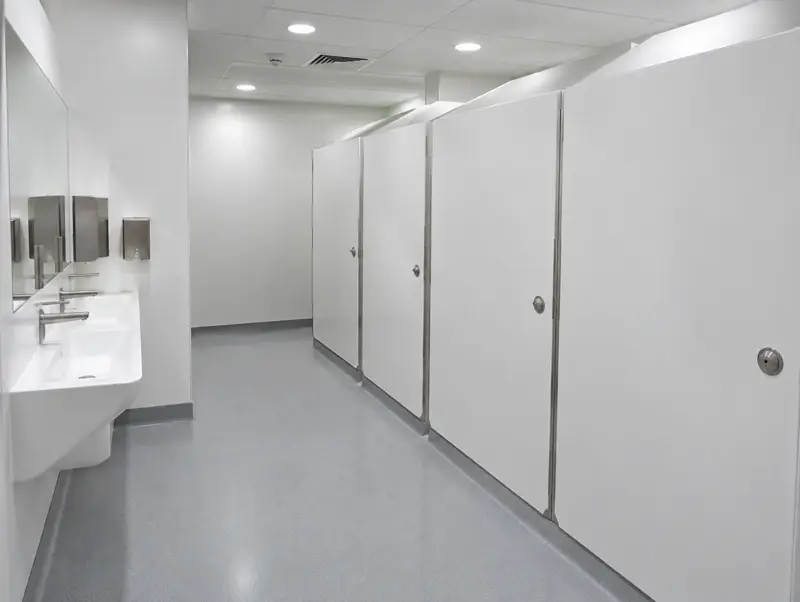 Hospital-grade washroom with anti-ligature white compact laminate cubicles